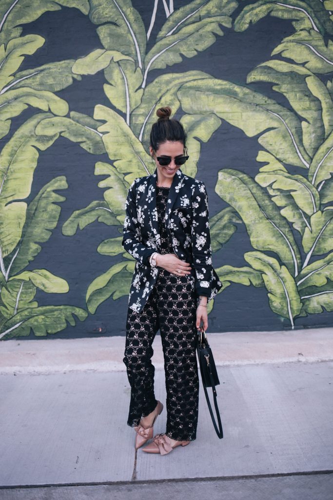Blogger Mary Krosnjar wearing lace jumpsuit and floral blazer from Rent the Runway