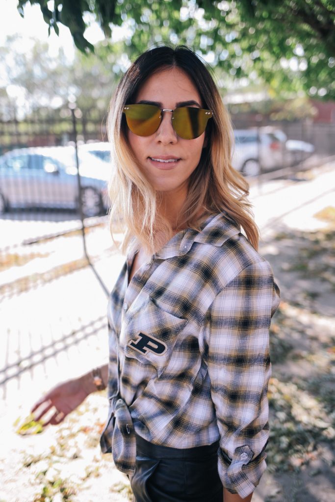Blogger Mary Krosnjar wearing Spitfire Gold Mirrored Sunglasses and plaid Purdue University flannel