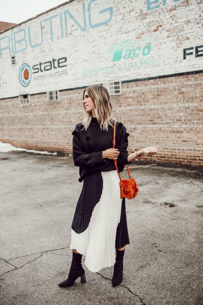 Blogger Mary Krosnjar wearing Rachel Parcell Black Pom Pom Sweater and H&M pleated skirt
