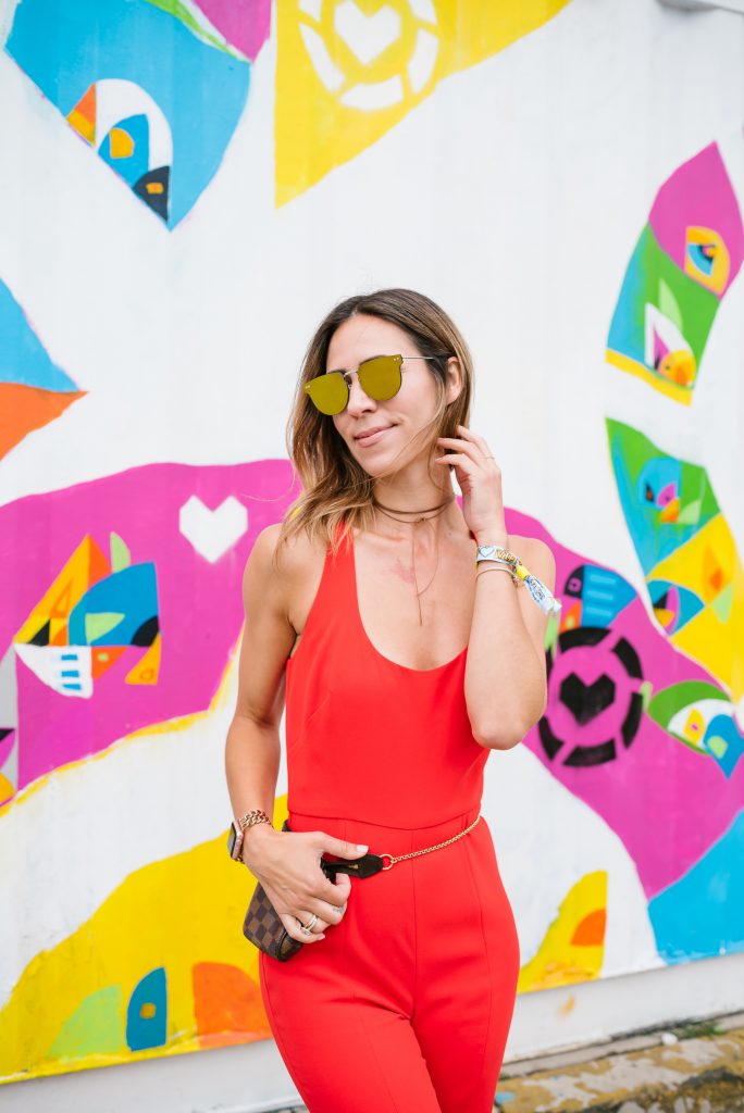 Blogger Mary Krosnjar wearing red flare jumpsuit and gold mirrored sunglasses