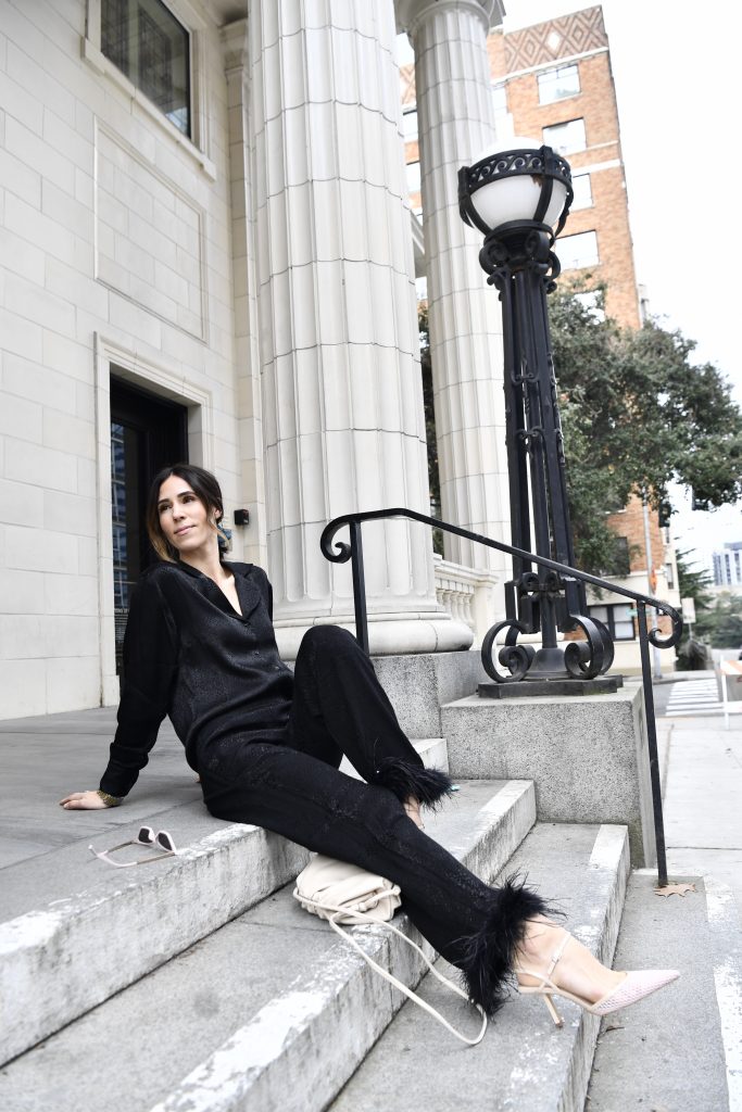 Blogger Mary Krosnjar wearing black silk blouse and black silk pants with ostrich feather trim
