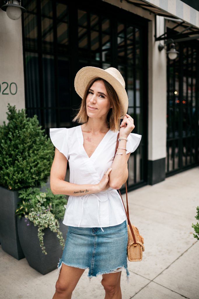 Seattle Fashion Blogger wearing white blouse and distressed denim skirt with summer straw hat