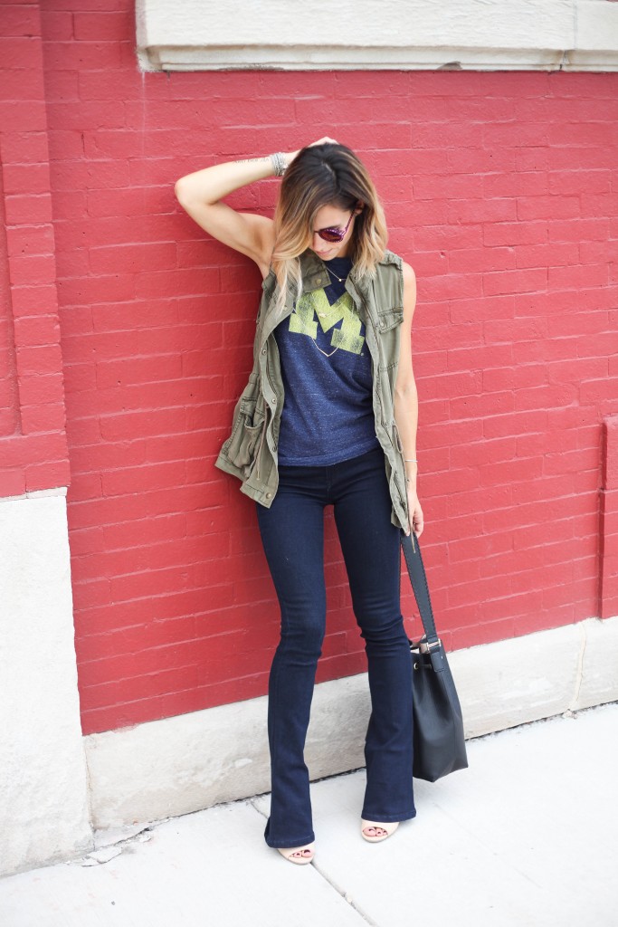 House of Holland Cagefighter sunglasses, Black bucket bag, University of Michigan Muscle Tee, Game day fashion, game day fashion ideas, what to wear to a football game, Olive khaki Vest, Nude open-toe mules, Henry & Bell Micro Flare Denim, University of Michigan, Michigan Wolverines