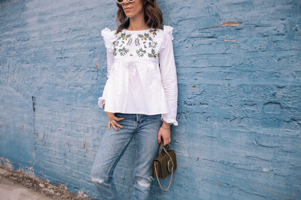 Blogger Mary Krosnjar wearing White Embroidery Ruffle Trim Pleated Blouse and distressed denim