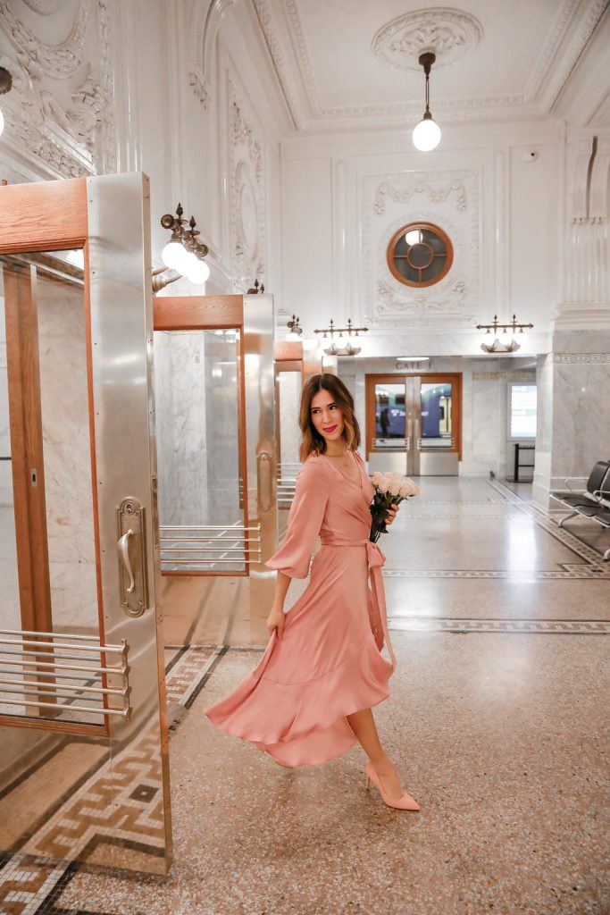 Blogger Sportsanista wearing Gal Meets Glam pink silk wrap dress and Pink Suede Pumps
