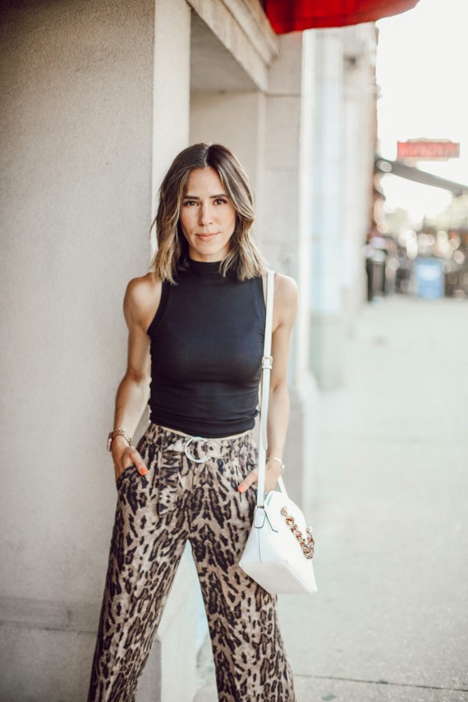 Fashion Blogger Sportsanista wearing a black mockneck sleeveless turtleneck and wide leg leopard pants for work